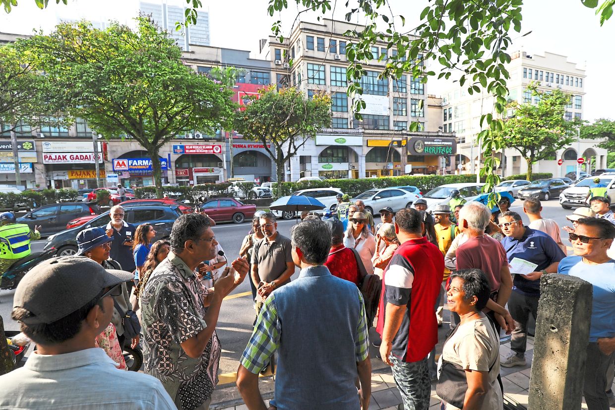 Prabhakaran (second from left, with mini microphone) explaining the history of Sentul Raya Boulevard, which was once an open space used by the railway community.