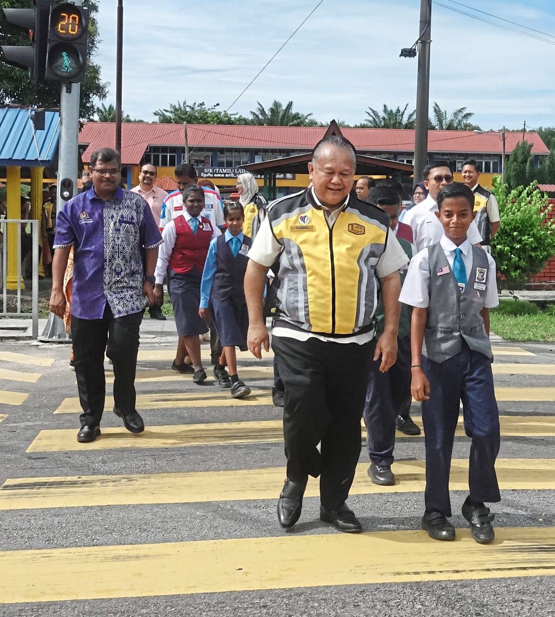 Safety first: Nanta joining schoolchildren in crossing the road during the launch.