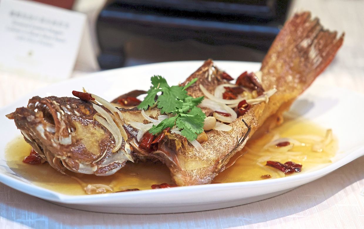 The deep-fried Sabah deep-sea star grouper braised with dried chillies and chicken stock offers a crispy yet tender combination.