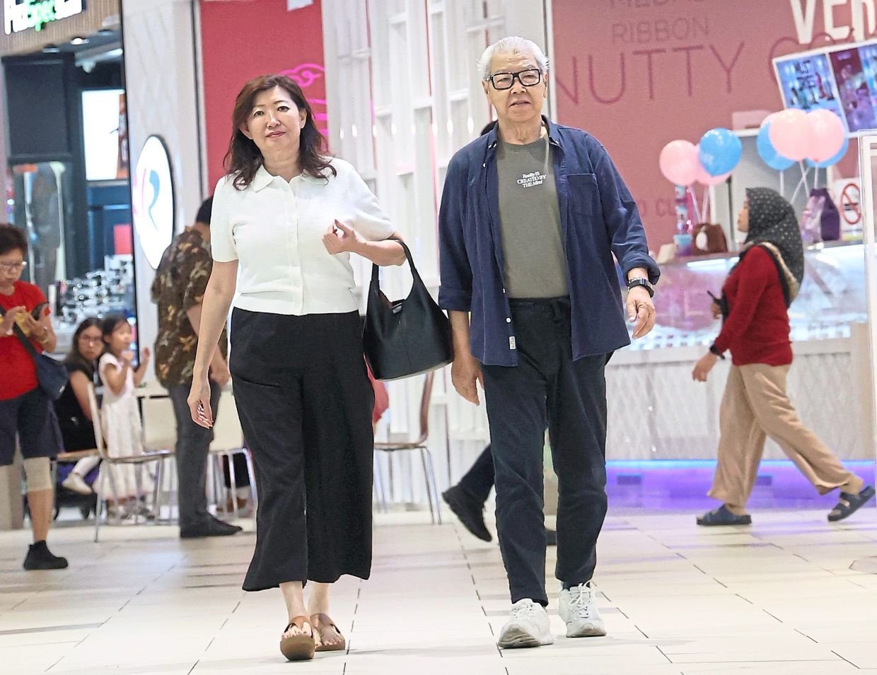Goh (right) and his wife Tang go to two shopping centres every day to clock up enough steps. — Photos: ART CHEN, LOW LAY PHON/The Star, courtesy and filepic
