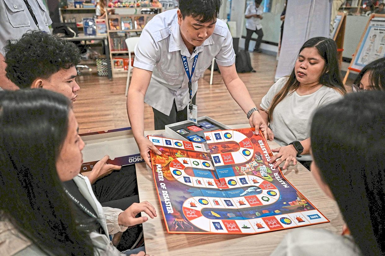 A man preparing a board as he explains the rules of the game at a library in Valenzuela, Metro Manila. — AFP