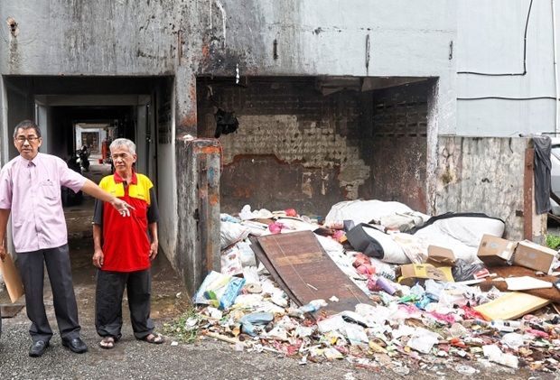Yee (second from right) showing the overflowing refuse area at the low-cost flats in Batu Caves.