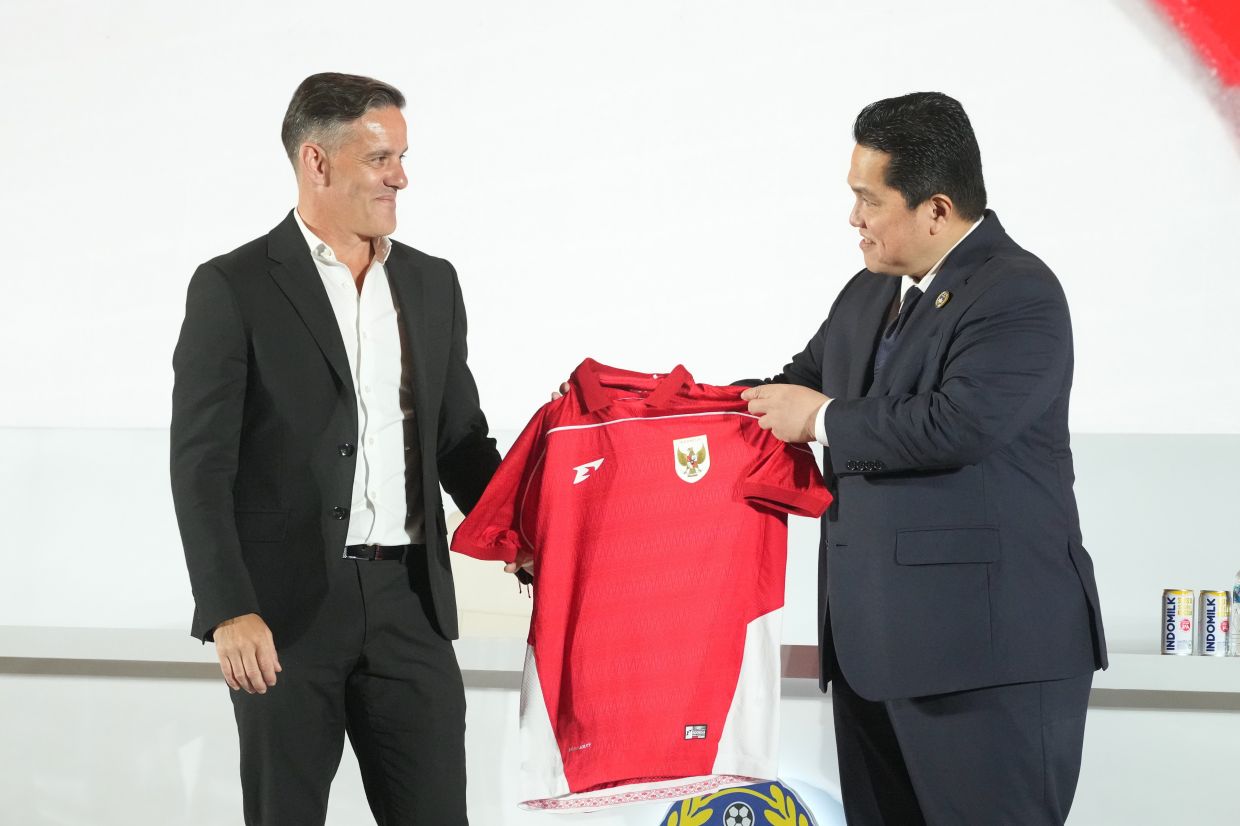 Chairman of Indonesian Soccer Association Erick Thohir (right) presents a team jersey to the newly appointed head coach of Indonesia's national team, John Herdman, during a press conference in Jakarta, Indonesia, Tuesday, Jan. 13, 2026. -- AP Photo/Achmad Ibrahim