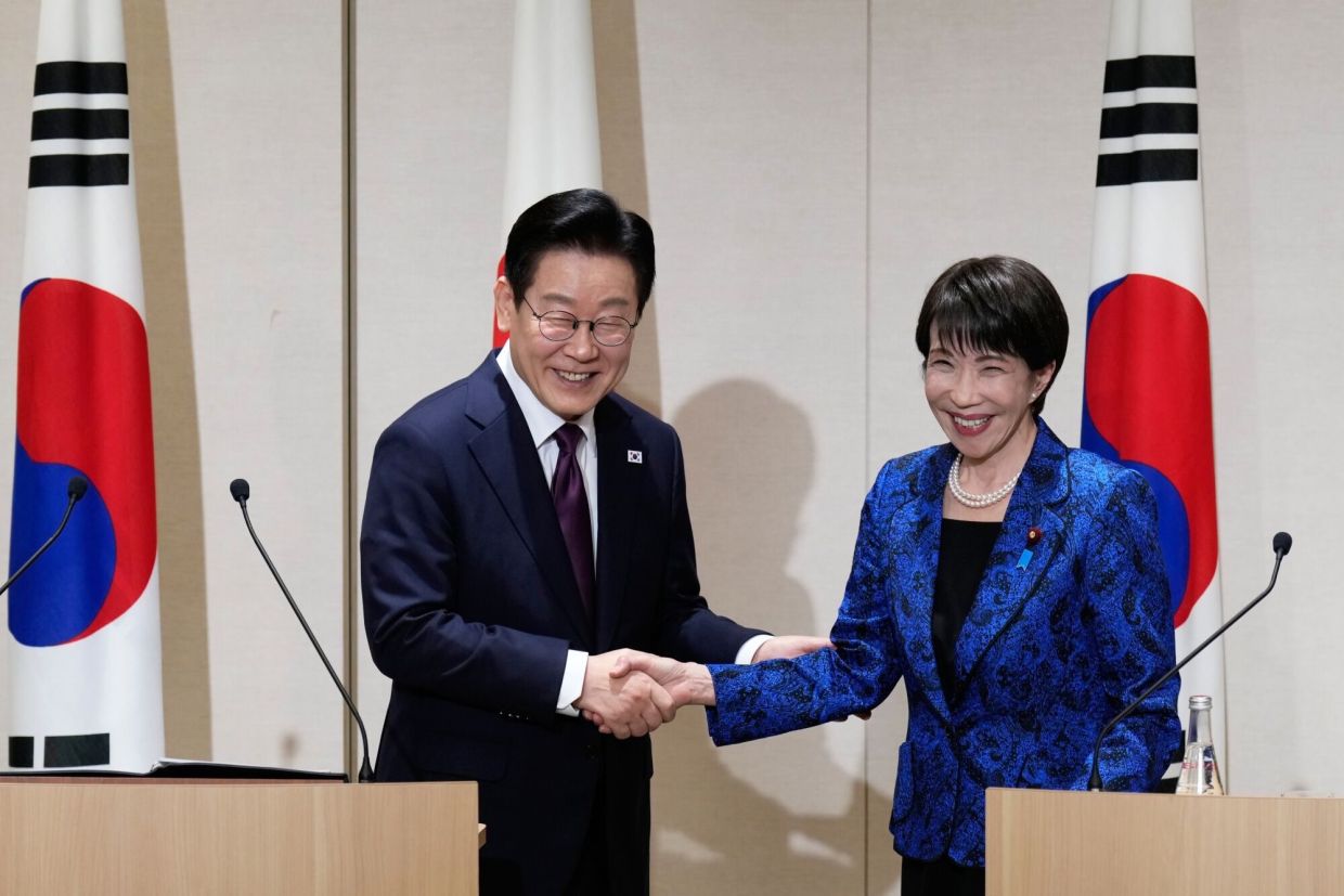 Lee Jae Myung, South Korea's President (left), shakes hands with Sanae Takaichi, Japan's prime minister, during a joint news conference in Nara, Japan, on Tuesday, Jan. 13, 2026. Takaichi said during a summit with Lee that she hopes to elevate the nations’ relationship, as Tokyo moves to contain a deepening diplomatic and trade dispute with China and counter Beijing’s efforts to drive a wedge between key US allies. -- Photographer: Eugene Hoshiko/AP Photo/Bloomberg