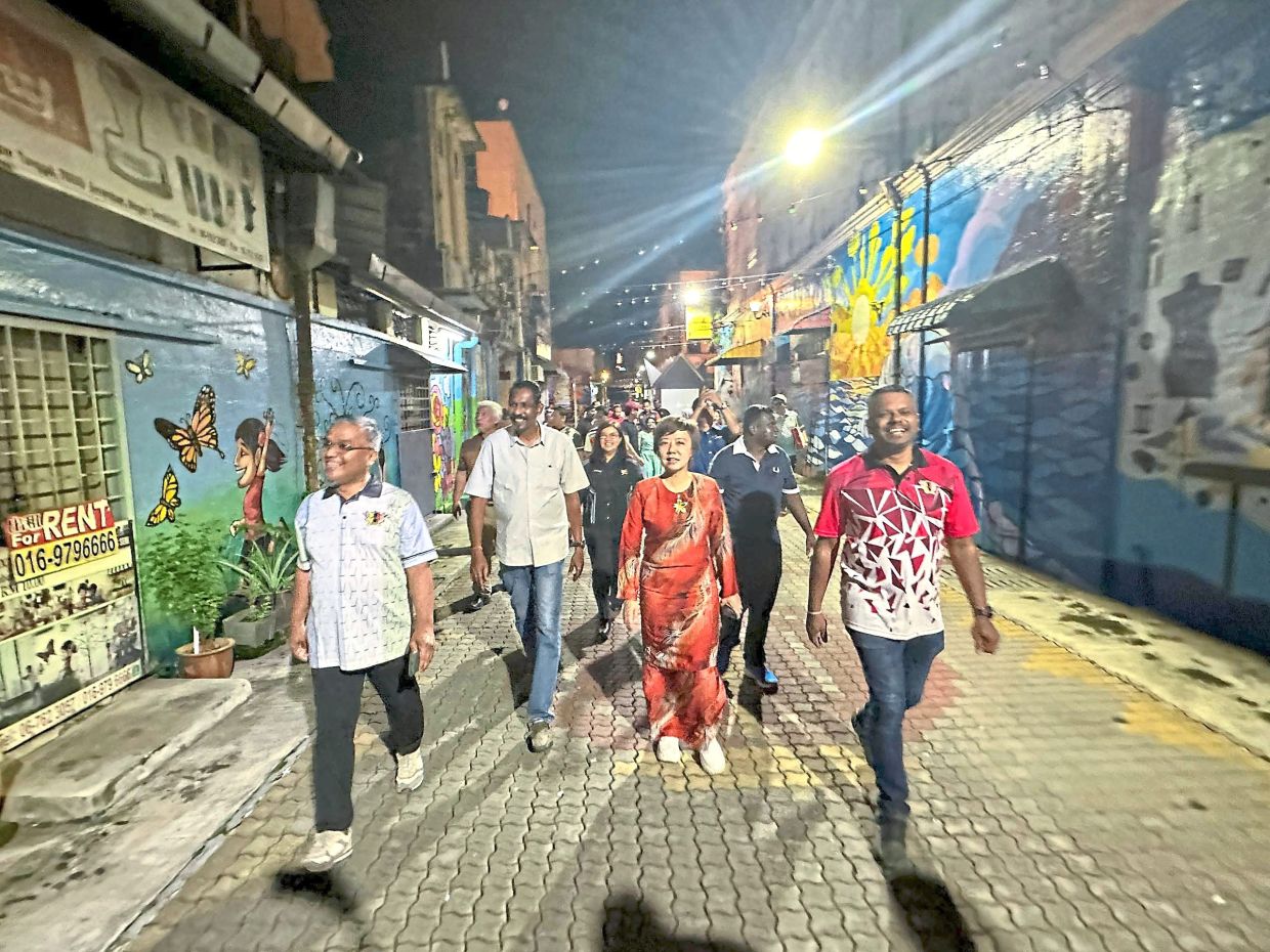 Tan (centre) taking a stroll along Lorong Seni which has been recognised by the Malaysia Book of Records as the longest art alley in the country.