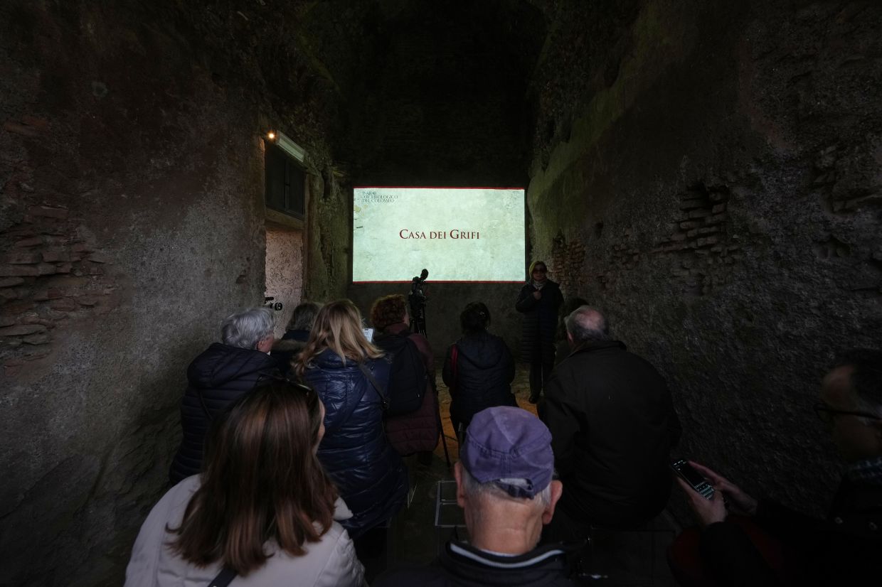 Reporters watch a livestream guided tour for the press of the newly-restored underground House of Griffins, dated between the II and I century B.C., on the Palatine Hill next to the Colosseum, in Rome. — AP