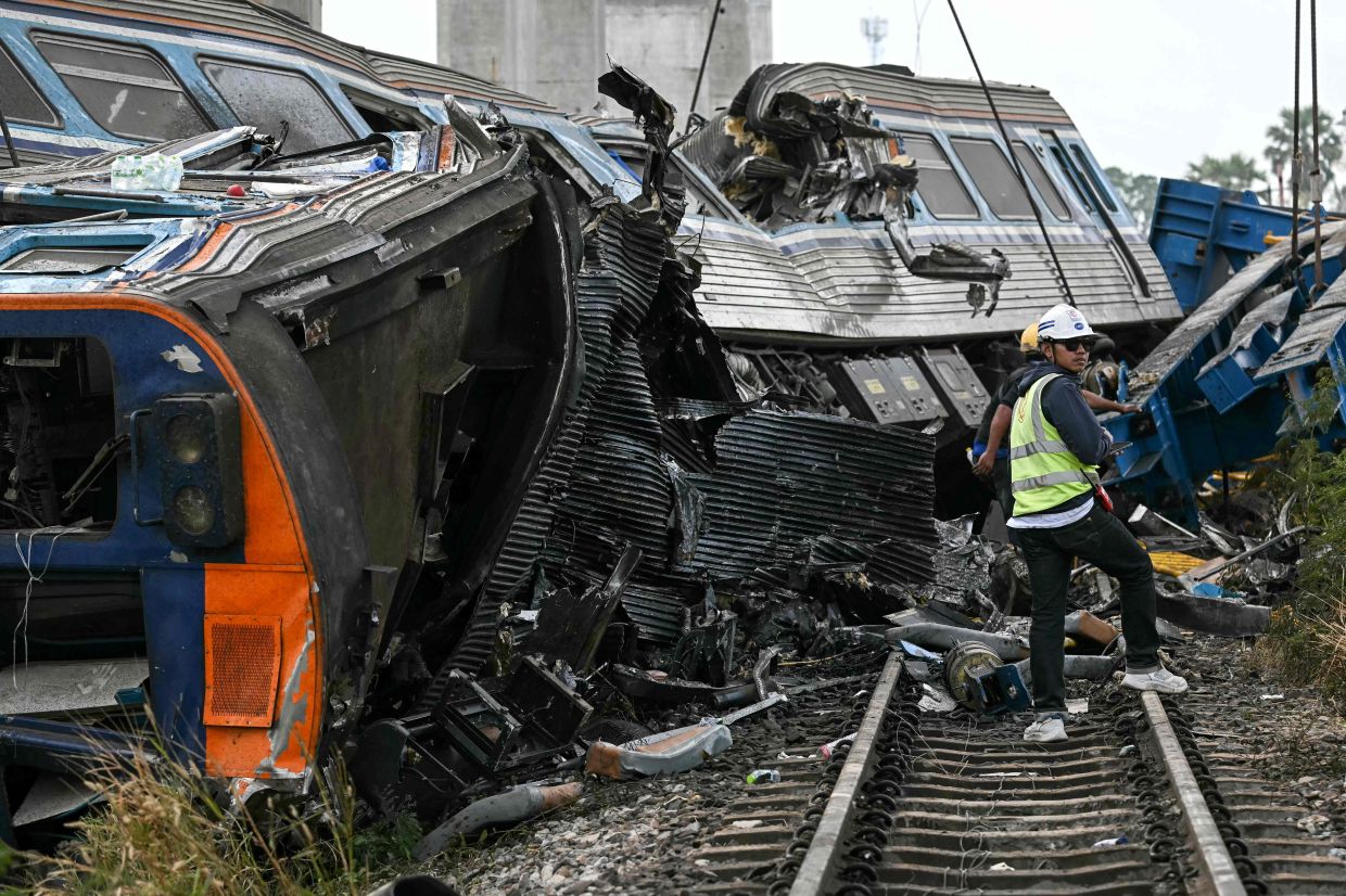 A recovery worker stands next to the wreckage of a train that crashed when a construction crane collapsed in Thailand's Nakhon Ratchasima province on Jan 14, 2026. A crane at a China-backed high-speed rail project in Thailand collapsed onto a passenger train on Jan 14 and caused it to derail, killing at least 28 people and injuring dozens more, authorities said. - Photo: AFP