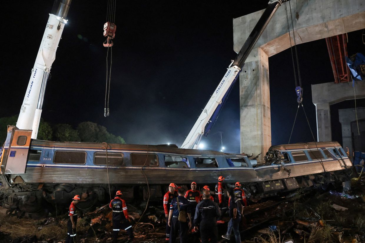 Rescue workers search the site where a train was derailed when a construction crane collapsed and fell onto its carriages, causing several casualties, in Sikhio district, Nakhon Ratchasima province, Thailand, January 14, 2026. REUTERS/Chalinee ThirasupaTPX IMAGES OF THE DAY