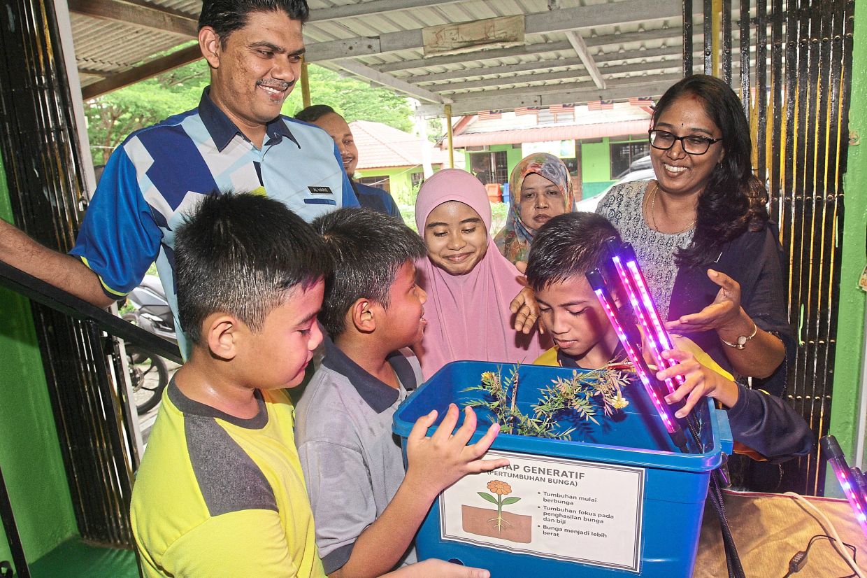 Left: SK Tanjung Bunga pupils, teacher Gourmet Vediappan (right) and Baba (left) with part of their project using LED lighting to promote plant growth. — Photos: LIM BENG TATT/The Star