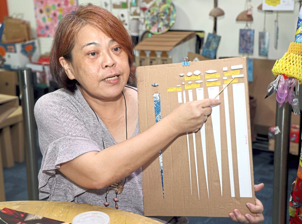 Tan showing paper strips of varying sizes that are rolled into beads of different designs and patterns.