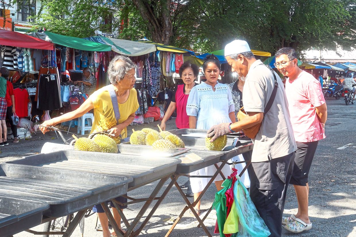 Customers buying durian from Mohd Latib.