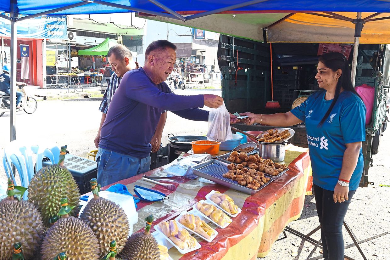 Sarania purchasing deep-fried ‘cempedak’ from Chee.