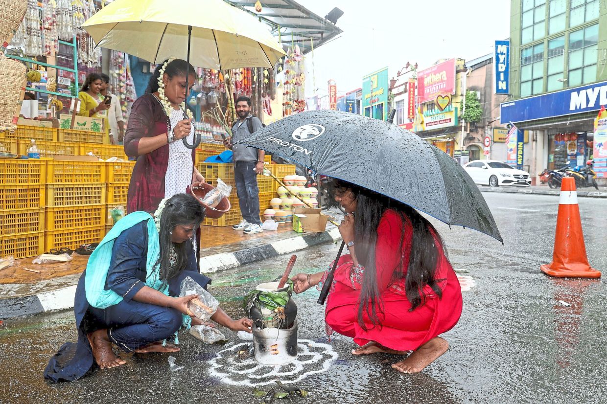 Joining in the festival: Shop workers preparing ponggal at their store at Jalan Tengku Kelana in Klang yesterday.— KK SHAM/The Star