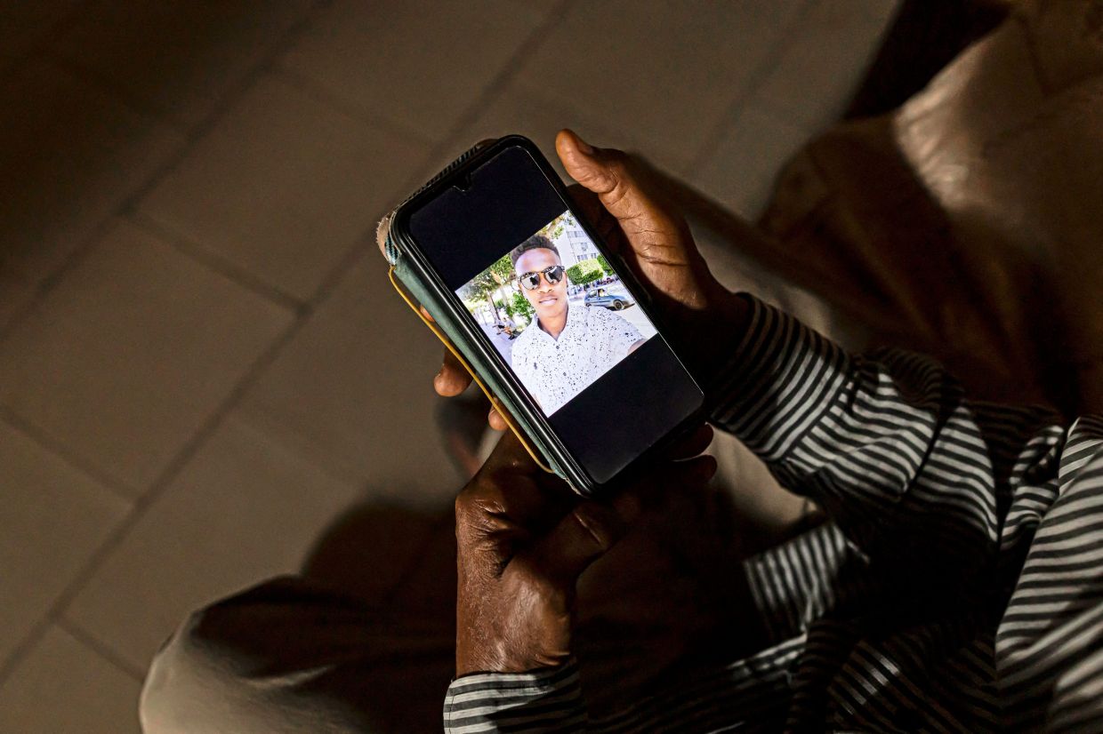 All he has to remember his son, Abdou Karin, is a photo on his handphone. — AFP