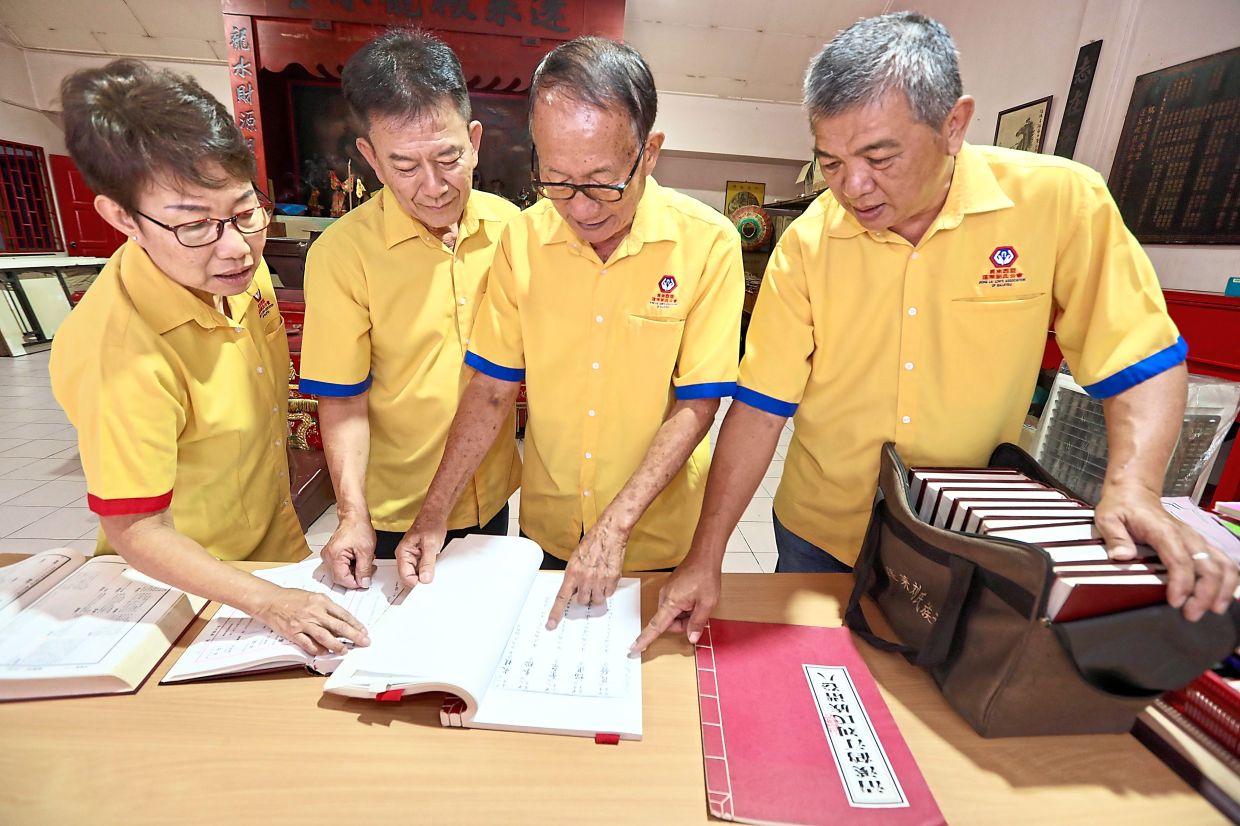 (From left) PKHLLM women wing advisor Low Siew Ngo, president Low Kok Bin, Kim Chun and Jin Boon studying their genealogy at the association’s premises in Kepong, Kuala Lumpur.