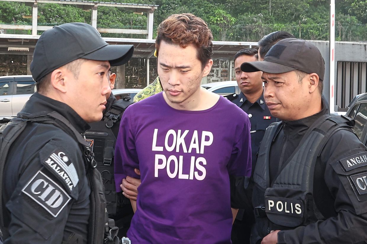Under heavy guard: Chia arriving at the Johor Baru Court Complex accompanied by police security to face a total of four charges, including two for allegedly murdering his wife and son. — THOMAS YONG/The Star