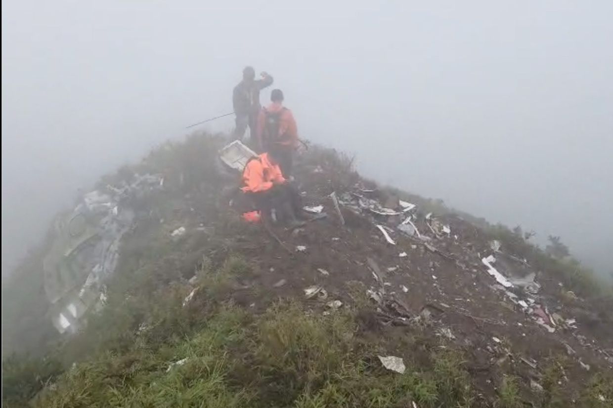 Members of its rescue team conduct a searching operation amid debris of an airplane around Mount Bulusaraung, South Sulawesi province, Indonesia, Sunday, Jan. 18, 2026, after the turboprop ATR 42-500 lost contact Saturday. -- BASARNAS via AP