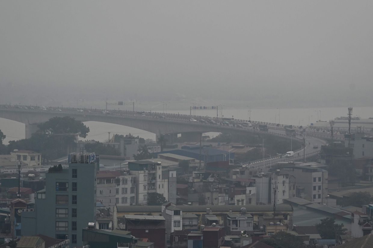 A general view shows buildings amid air pollution in Hanoi. -- Photo by Nhac NGUYEN / AFP