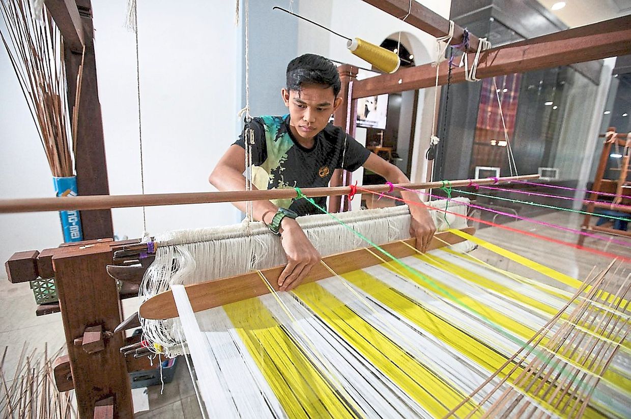 Mohamad Sharil at the loom weaving Kain Benang Johor. 