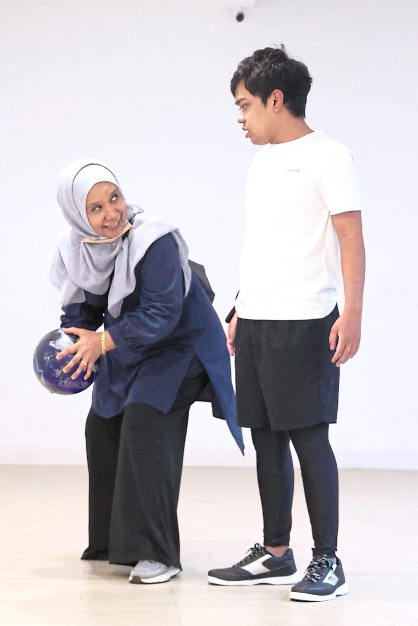 Zaliah (left) sharing a moment with her son Omar during a bowling training session. 