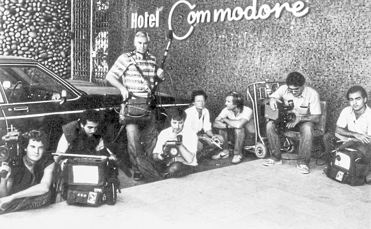 Television crew, some wearing flak jackets, crouching down in front of the Commodore Hotel on Aug 31,1983, when the Lebanese Army battled with militiamen. — BILL FOLEY/AP