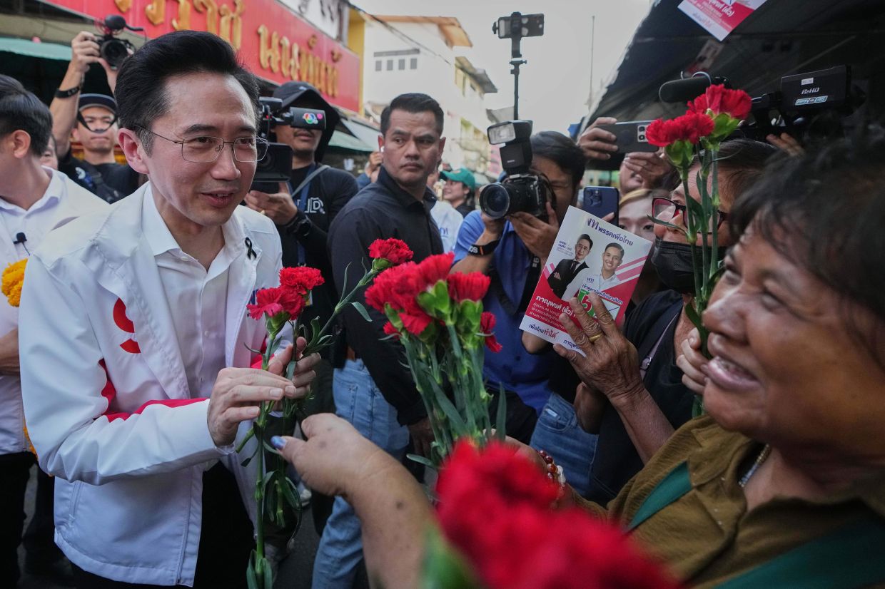 Pheu Thai Party prime minister candidate Yodchanan Wongsawat (left) receives flowers from his supporters during an election campaign event in Nonthaburi Province, Thailand, Monday, Jan 19, 2026. -- AP Photo/Sakchai Lalit
