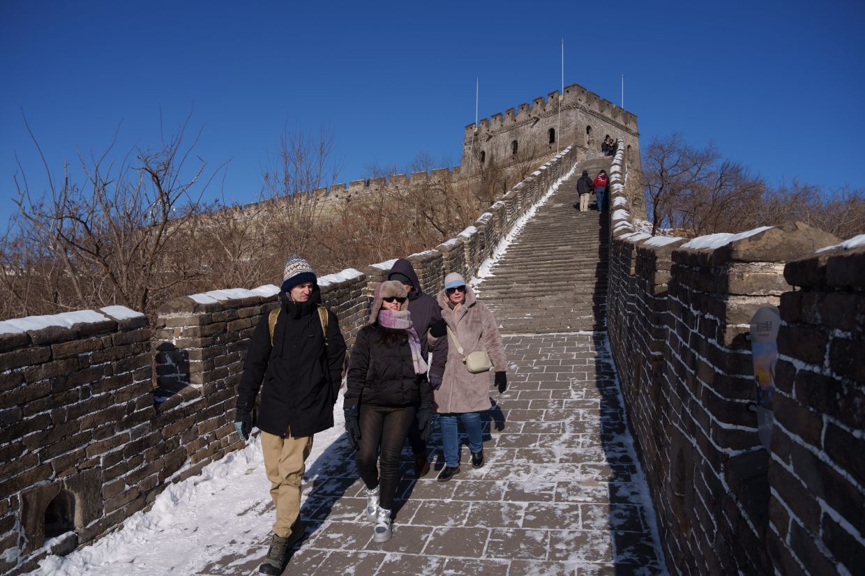 Tourists walk at Juyongguan section of the Great Wall, on the outskirts of Beijing, China, Monday, Jan. 19, 2026. -- AP Photo/Vincent Thian