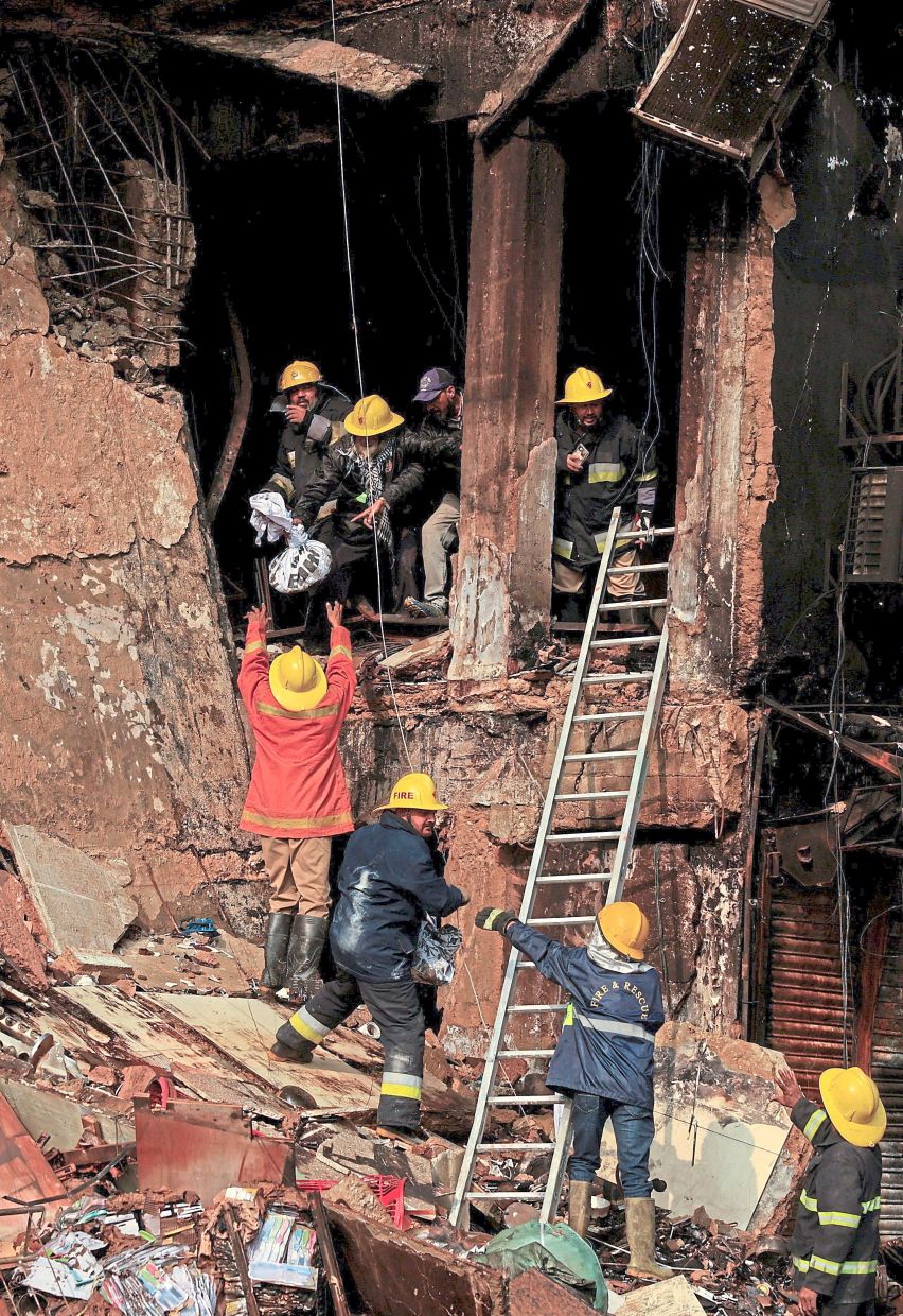 Seeking signs of life: Emergency personnel at the scene following the massive fire that broke out in the Gul Plaza Shopping Mall in Karachi.