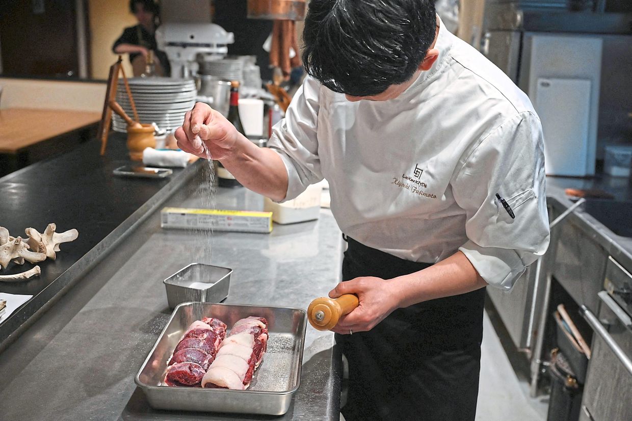 Chef Fujimoto seasoning bear meat at his restaurant in Sapporo, in Japan’s northern Hokkaido prefecture, in this photo taken on Dec 9, 2025. — AFP
