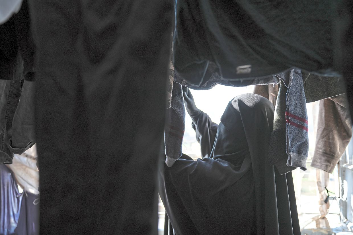 Zainab hangs clothes to air dry at her father’s house where she has been living since she returned from a­l-Hol camp after living there for six years.
