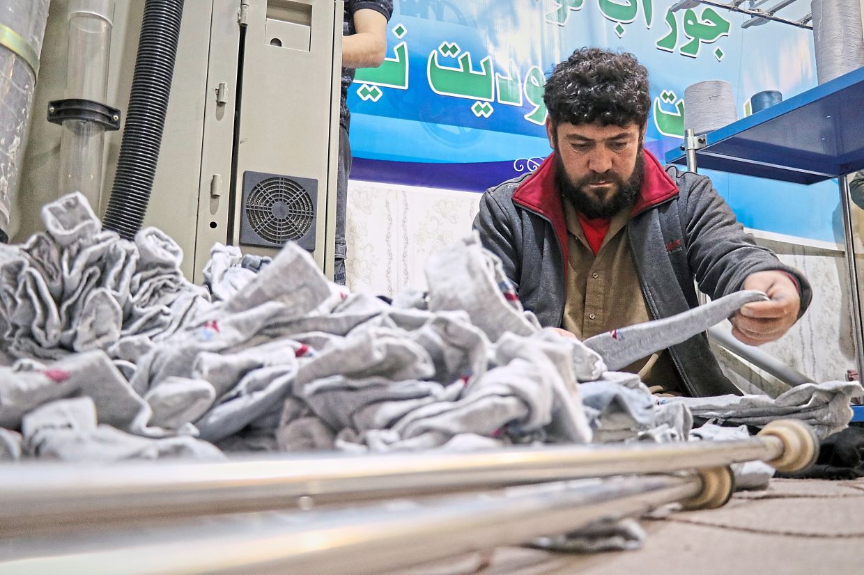 Shahabuddin sorts freshly made socks to be packaged in a sock workshop staffed entirely by men with disabilities in the western Afghan city of Herat, Afghanistan. —Photos: AP