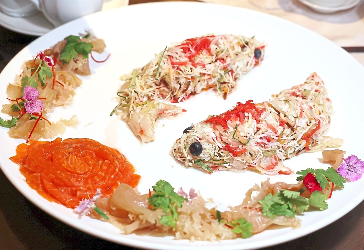 Prosperity Yee Sang with Salmon and Jellyfish artfully presented as a pair of koi swimming on a plate.