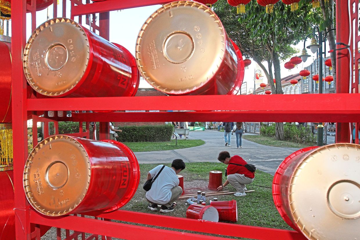 Volunteers turning discarded paint buckets into drums forming part of the Armenian Park decorations for CNY.