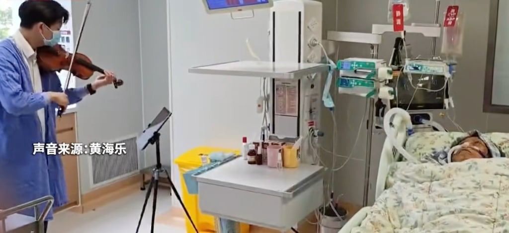 The violinist plays as Huang Haile’s illness-stricken mother lies in her hospital bed. - Photo: QQ.com