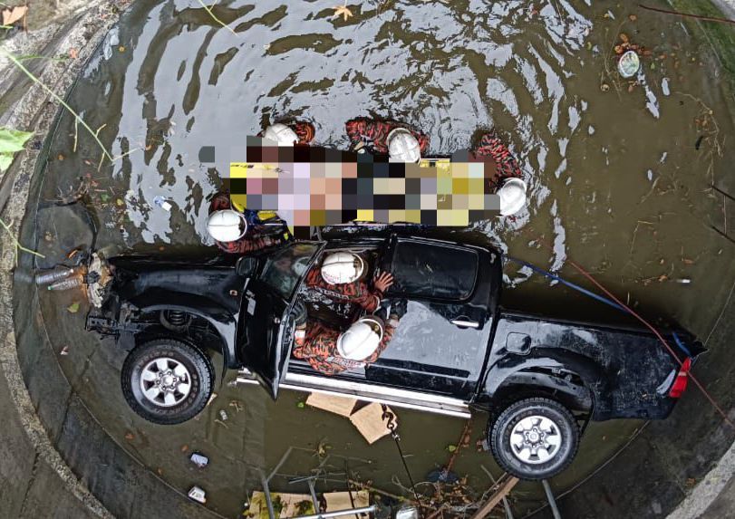 Firemen getting the victims out of the car from the hole.