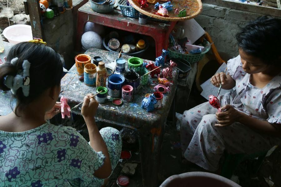 Women making handmade paper animal figures at a workshop in Yangon. - Xinhua