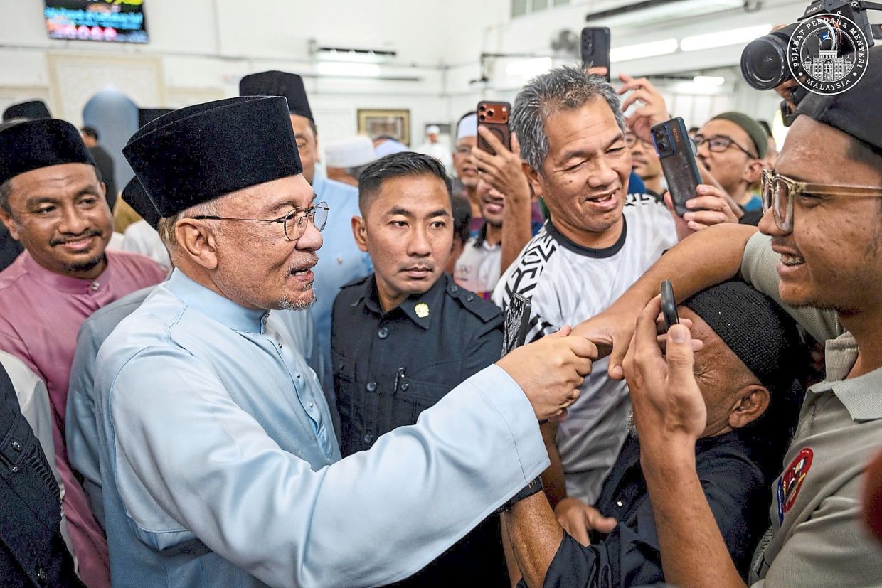 Greeting the people: Anwar greeting locals after performing Friday prayers at Surau Al Amin in Bandar Baru Bangi, Hulu Langat. — Prime Minister’s Department