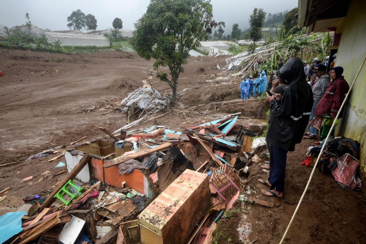 Debris from destroyed houses remains after a landslide struck in Pasirlangu village, Bandung, West Java, on January 24, 2026, as Indonesia's National Search and Rescue Agency (BASARNAS) said eight people were killed, and 82 remain missing. -- Photo by Timur Matahari / AFP