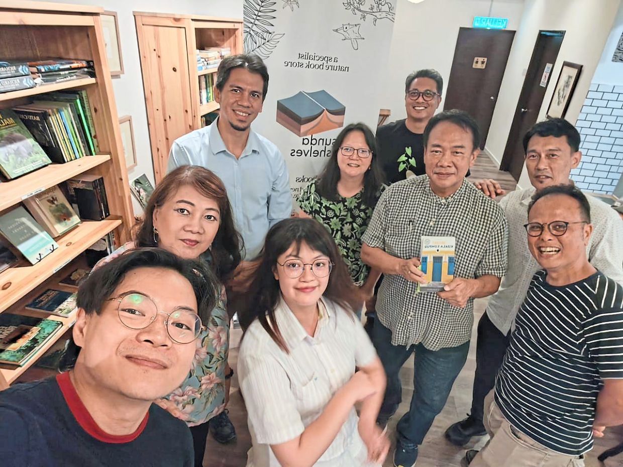 Lam, holding a copy of his book, poses with readers who attended his book talk at Sunda Shelves in Petaling Jaya last November. – Sunda Shelves