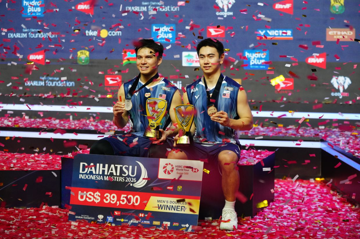 Malaysia's Goh Sze Fei, right, and Nur Izzuddin pose with their medal and trophies after winning against Indonesia's Raymond Indra and Nikolaus Joaquin in their men's doubles final match at the Indonesia Masters badminton tournament in Jakarta, Indonesia, on Sunday, Jan. 25, 2026. -- AP Photo/Tatan Syuflana