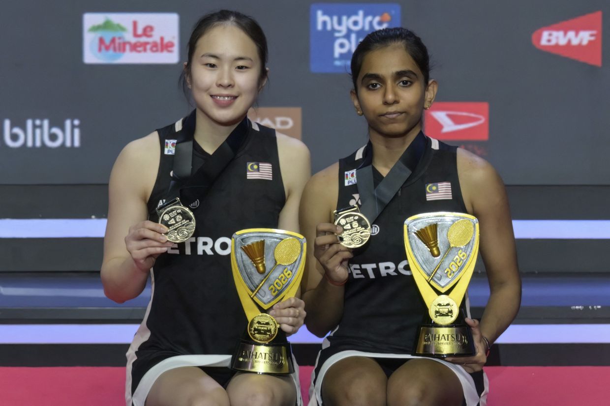 Malaysia's Pearly Tan and Thinaah Muralitharan pose on the podium after winning their women's doubles final match against Japan's Arisa Igarashi and Miyu Takahashi at the Indonesia Masters badminton tournament in Jakarta on Sunday, January 25, 2026. (Photo by BAY ISMOYO / AFP)