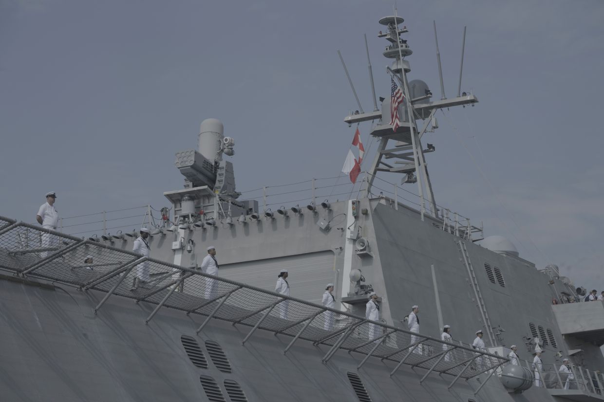 US warship USS Cincinnati's crew members stand on the ship for a welcome upon arrival at Ream Naval Base's pier in Sihanoukville, Cambodia. -AP Photo/Heng Sinith
