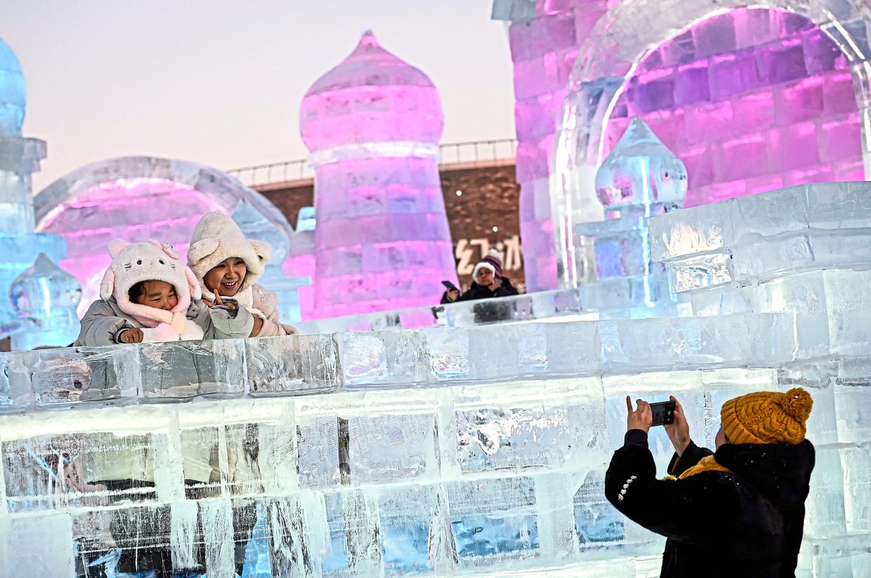 4. People posing with ice sculptures for photos during the festival’s opening ceremony. — AFP