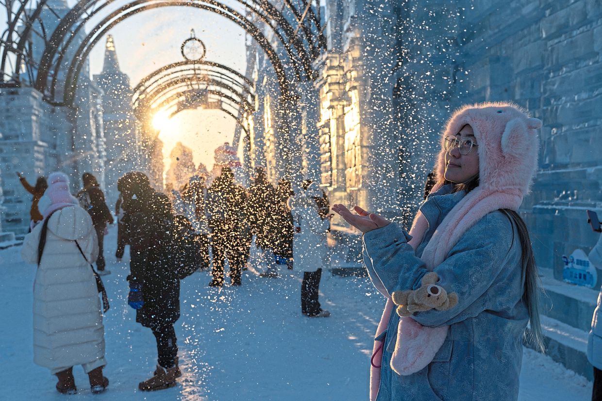 6. A visitor enjoying the man-made snow installations at the festival. — AP