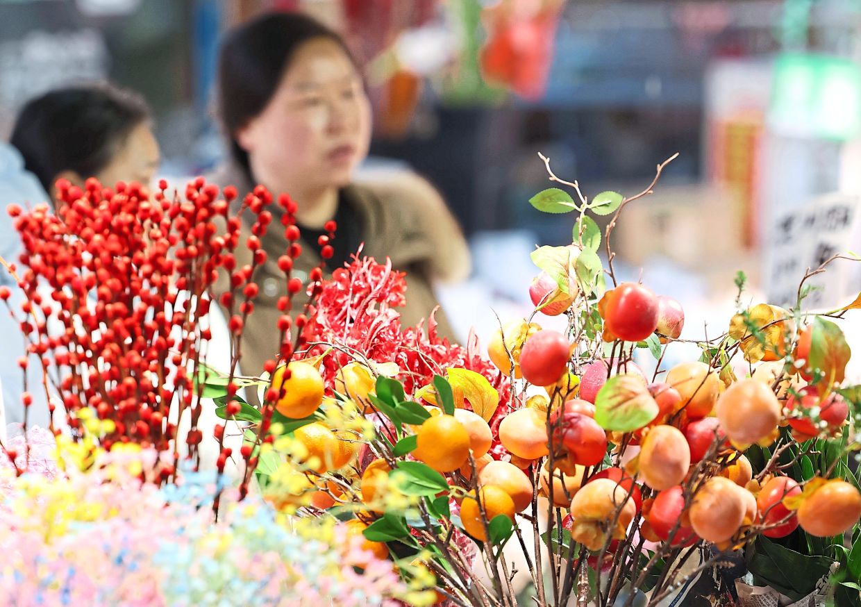 4. Visitors browsing the bustling floral market in Jianghan district, Wuhan, searching for New Year blooms and decorations. — Xinhua