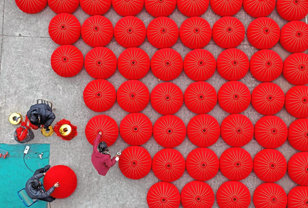 1. Aerial view of workers crafting vibrant red lanterns at a workshop in Taizhou, Zhejiang province, ahead of Chinese New Year. — Xinhua