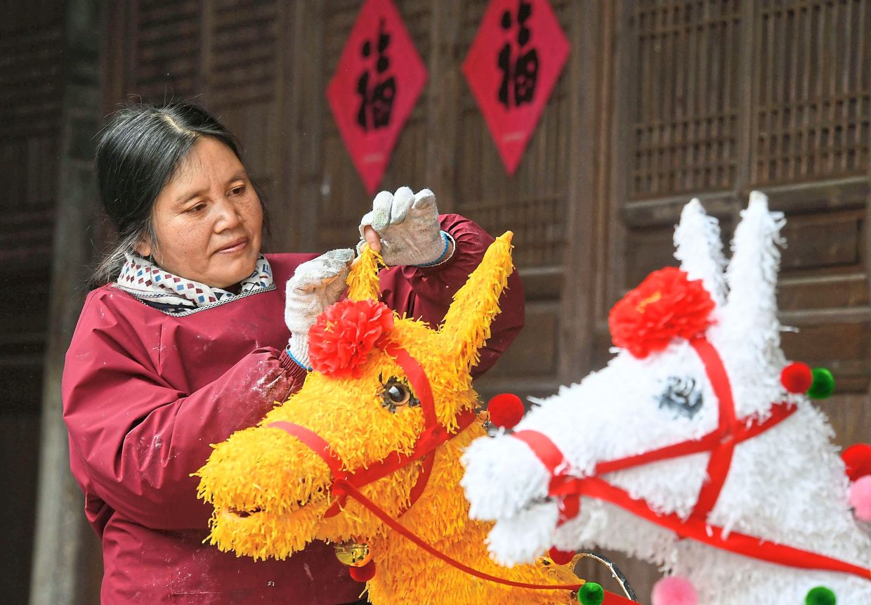 5. A villager creating traditional revolving horse lanterns at an ancient house in Zhoujia Village, Pujiang County, Jinhua City. — Xinhua