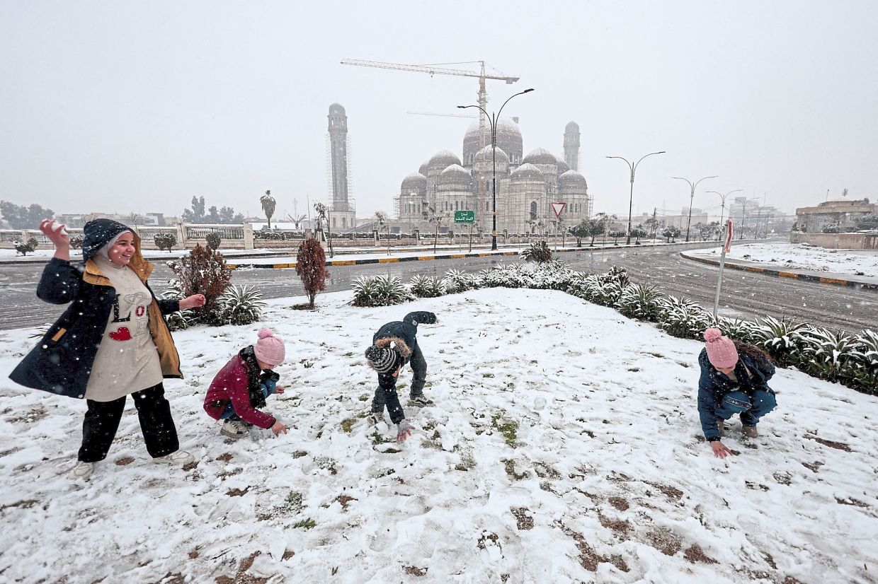 1. Children playing in the snow during a winter snowfall in Mosul, Iraq. — Reuters