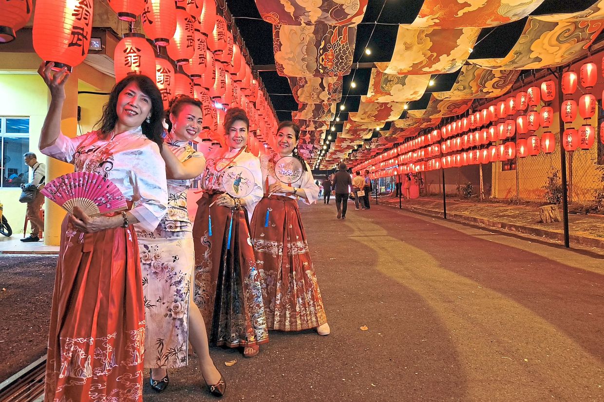 1. Women dressed in traditional Chinese costumes posing beneath lanterns ahead of Chinese New Year celebrations in Kg Permai Machap Umboo Baru, Alor Gajah, Melaka. — Bernama