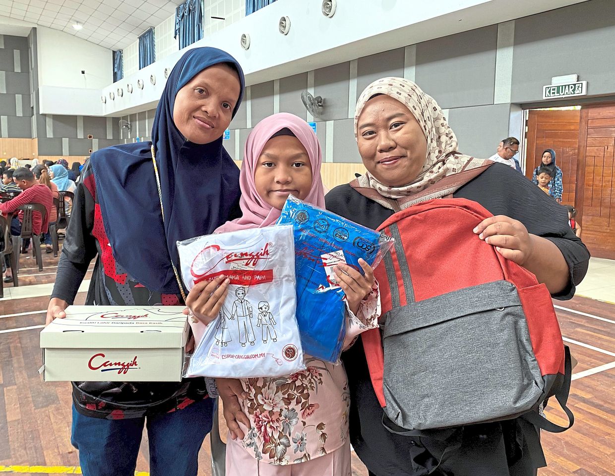 (From left) Norizan, her daughter and sister-in-law with the free school supplies received.
